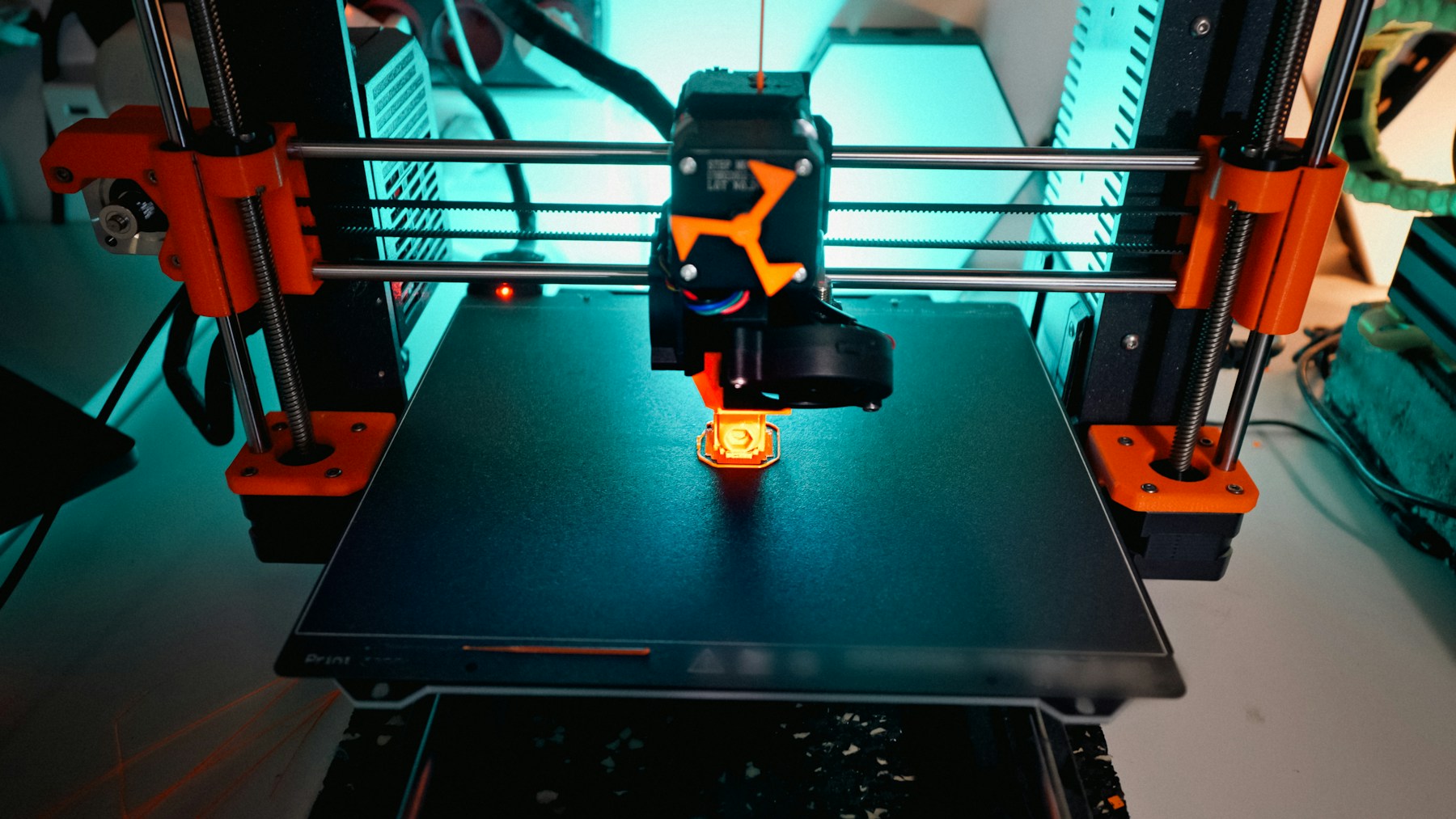3D printer creating a small object with visible first-layer adhesion